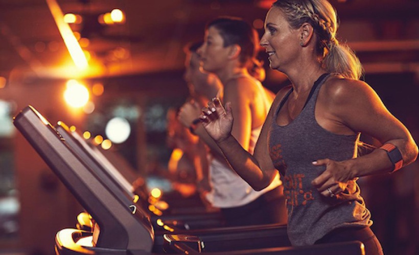 lifestyle image of a woman with others running on treadmills